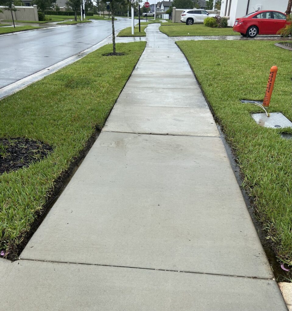 Community sidewalk after pressure washing by Aqua Blast