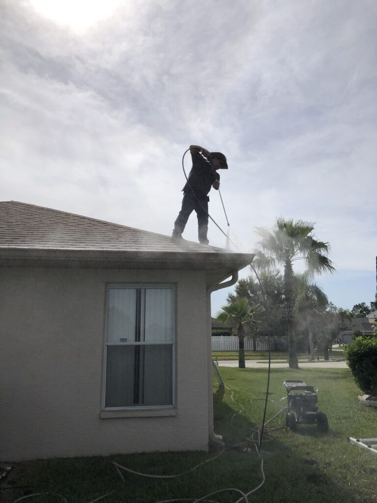 Aqua Blast crew member cleaning a shingle roof